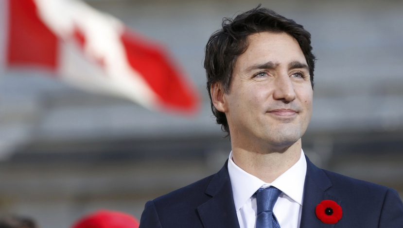 Justin Trudeau con lo sfondo della bandiera canadese