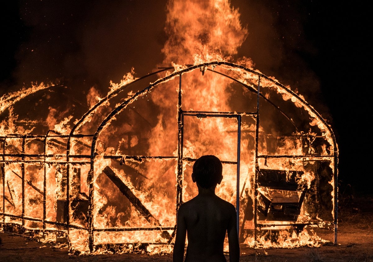 Un bimbo osserva la serra bruciare in una scena di Burning