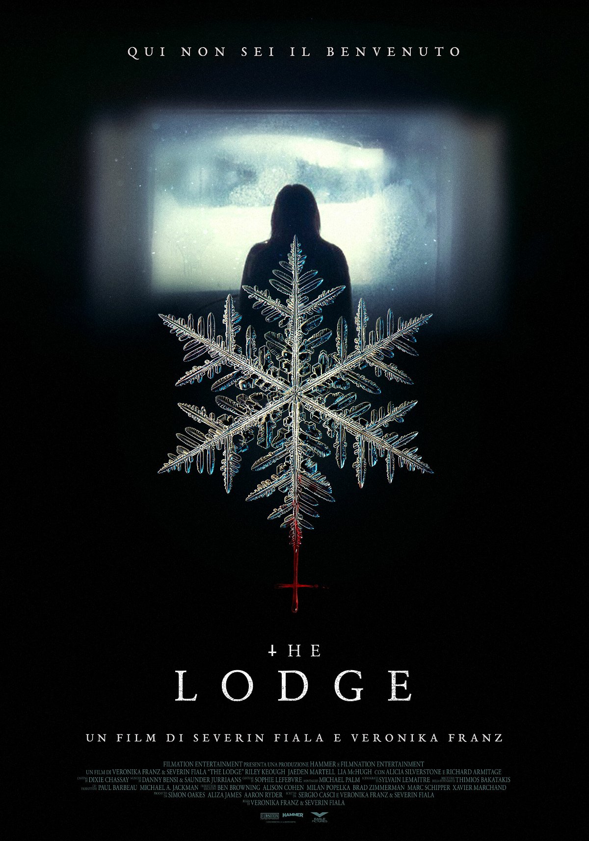 Un fiocco di neve cristallizzato al centro del poster, su sfondo nero, di The Lodge