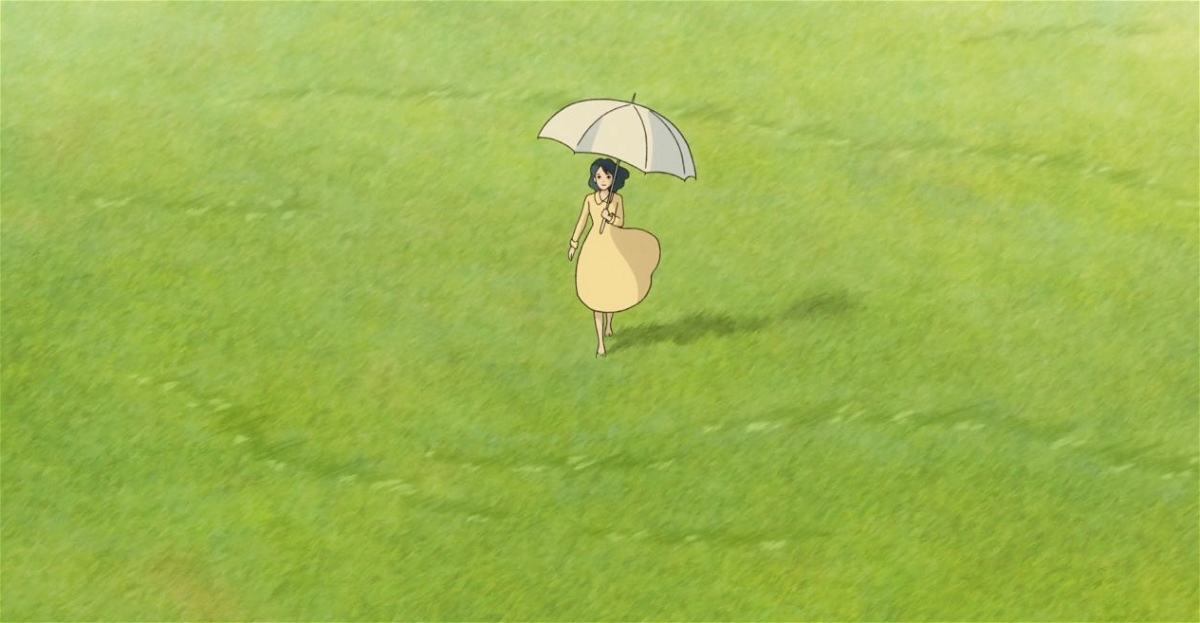 Nahoko cammina con un ombrello per ripararsi dal sole in una distesa erbosa nel sogno di Jiro