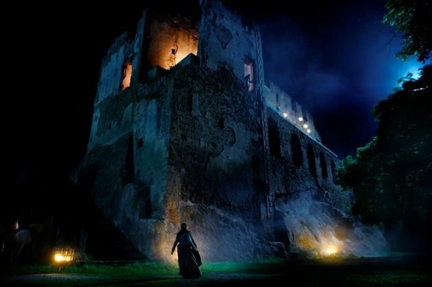 Una delle protagoniste di Luna Nera di fronte le rovine di un castello, di notte