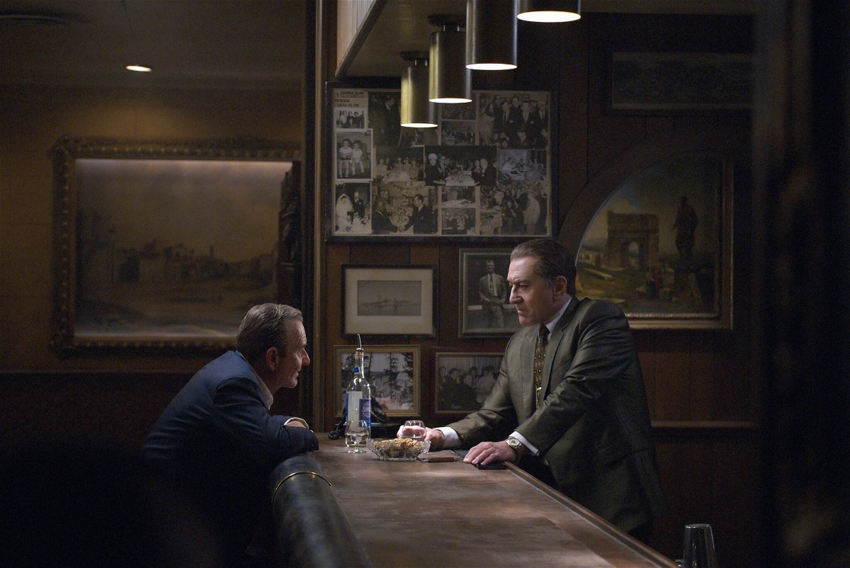 Joe Pesci seduto al bancone di un bar di fronte a Robert De Niro (in piedi)