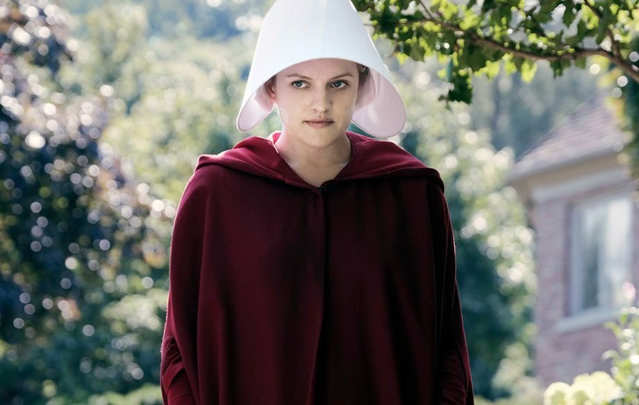 Difred (Elisabeth Moss) con mantello rosso e capello bianco