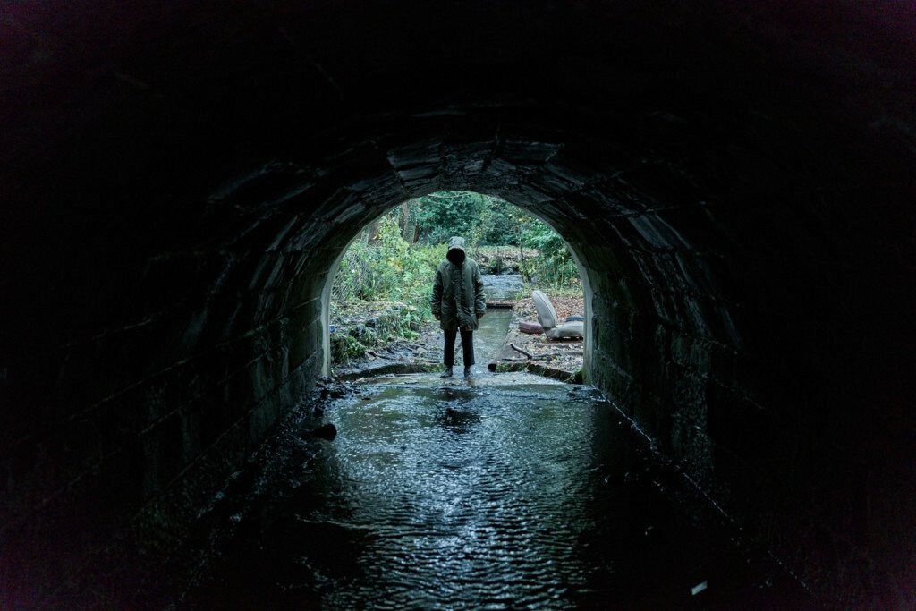 Un misterioso personaggio in fondo a un tunnel osserva lo spettatore