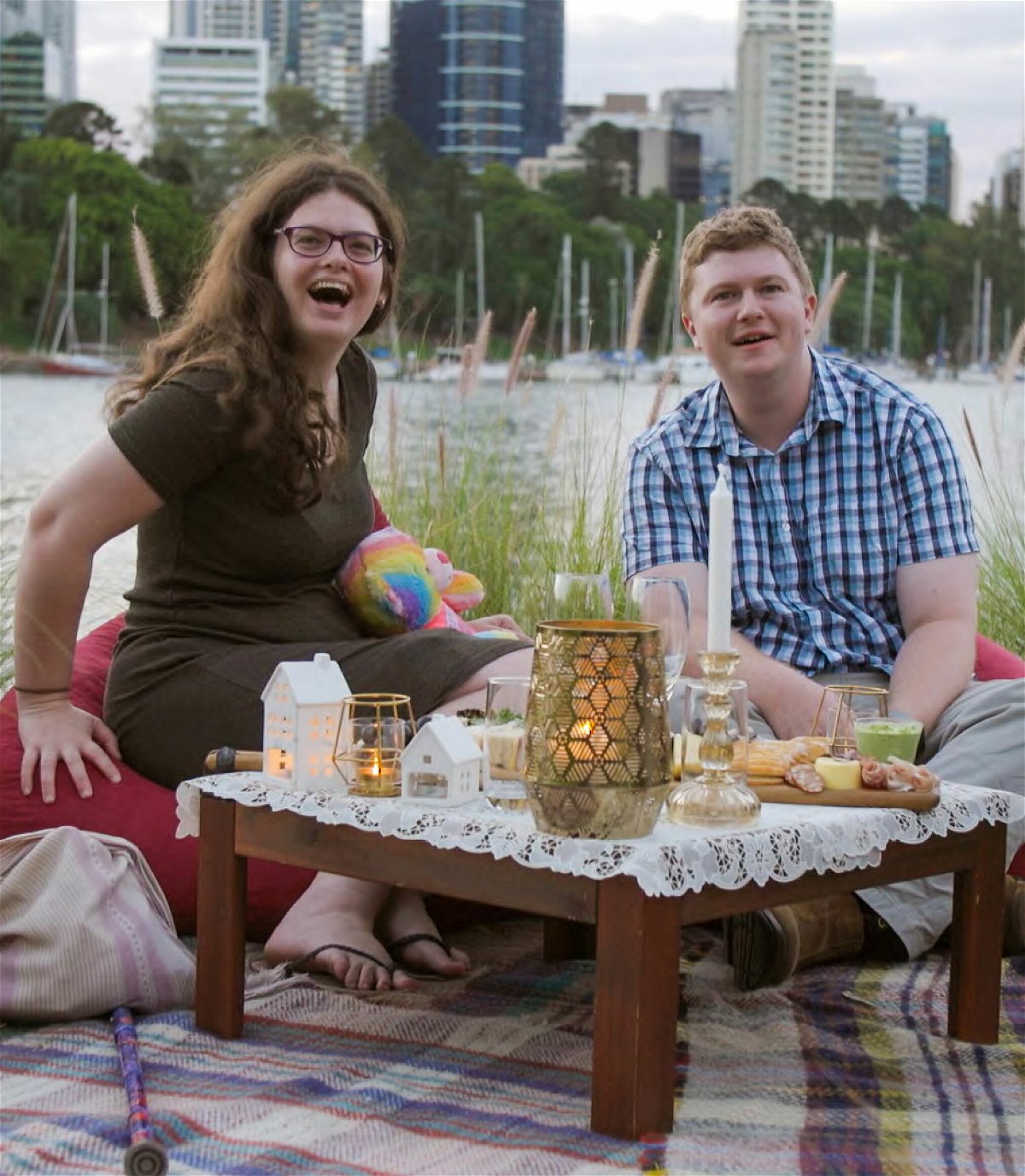 Ruth e Thomas seduti a un tavolino basso pieno di candele
