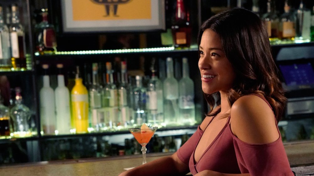 Mezzobusto di Gina Rodriguez seduta al bancone di un bar