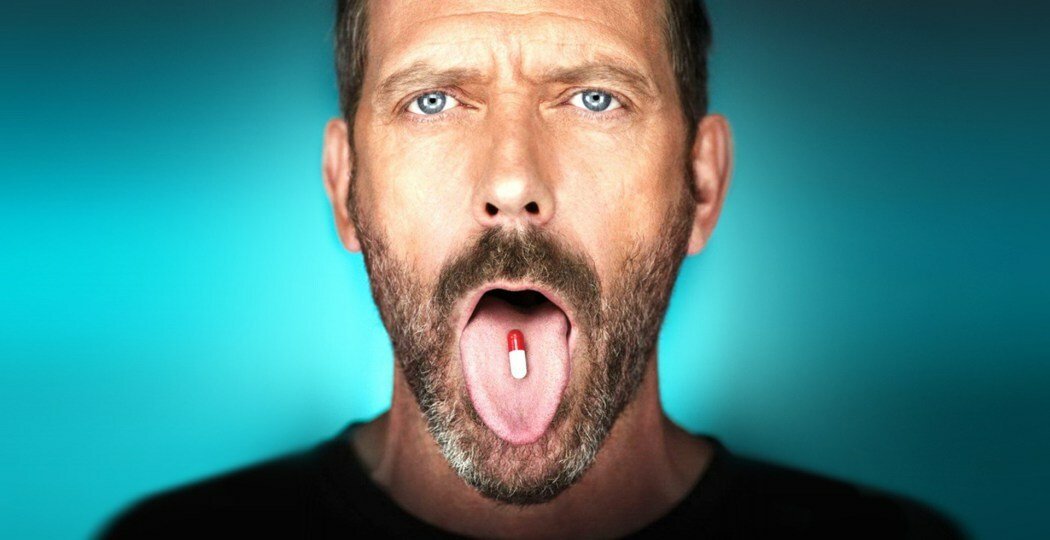 Dr. House con una pillola in bocca
