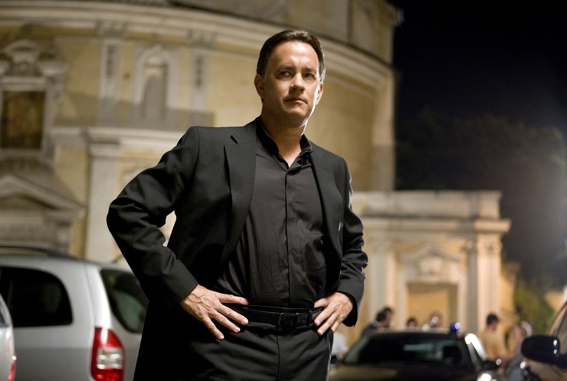 Tom Hanks nei panni di Robert Langdon, mani nei fianchi e un vestito nero
