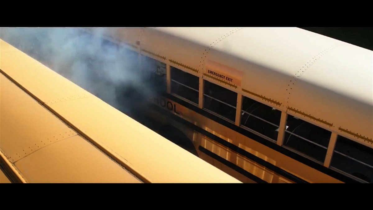 Una nuvola di fumo tra due bus arancioni tipici americani