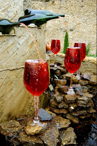 Una fontana eroga vino rosso sulle rocce