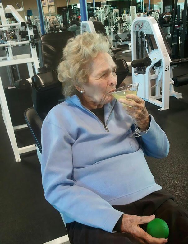 Primo piano di un'anziana che sorseggia un drink in palestra 