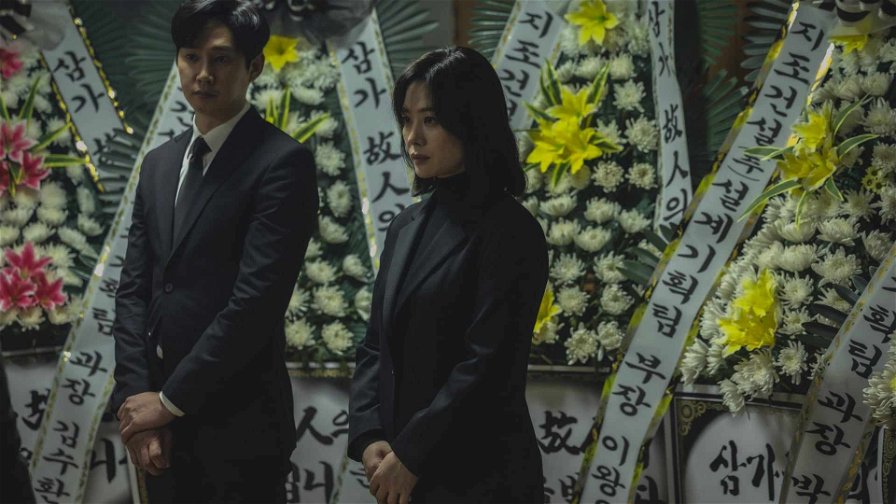 Eredità sepolta - Yun e il marito in piedi vicino a corone di fiori