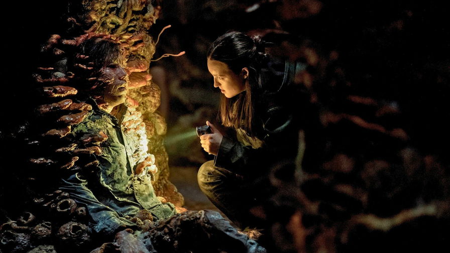 The Last of Us - Ellie guarda con la torcia un infetto