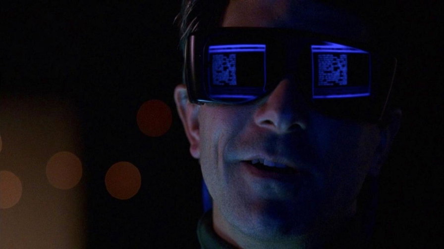 Dan Aykroyd indossa occhiali scuri sui quali si riflettono schermate blu